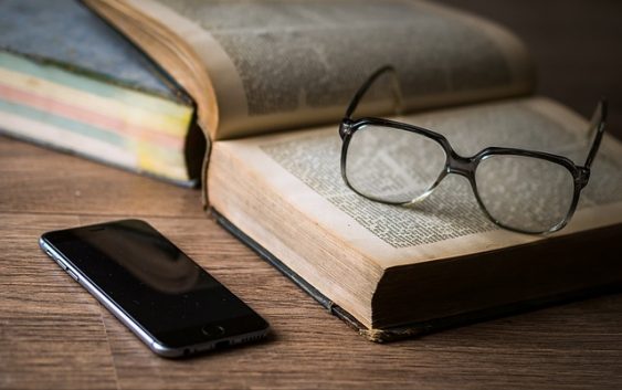 livros, óculos e telefone